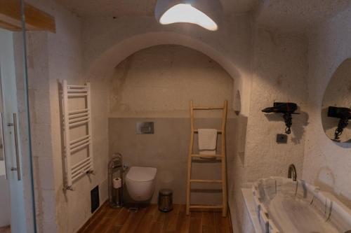 a bathroom with two sinks and a toilet in it at Potamia Cave Suites in Ortahisar