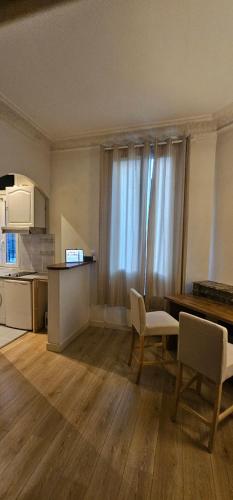 un salon avec une table et des chaises et une cuisine dans l'établissement Studio Cosy Clichy, à Clichy