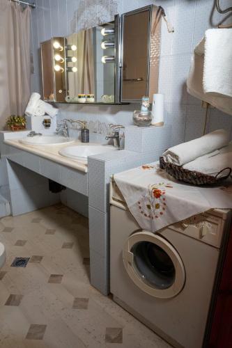 a bathroom with a washing machine and a sink at Paradeisos Rooms Pelion in Agios Dimitrios