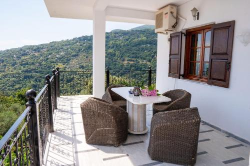 a patio with a table and chairs on a balcony at Paradeisos Rooms Pelion in Agios Dimitrios