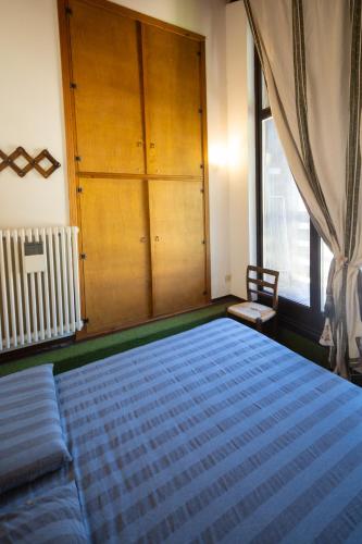 a bedroom with a bed and a cabinet and a window at Chalet Corona in Giustino