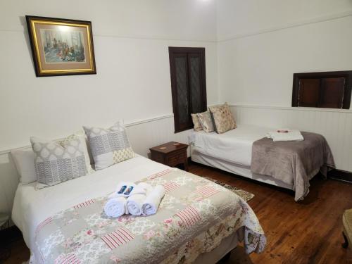 a bedroom with two beds with flip flops on the bed at CasaMia in Bredasdorp