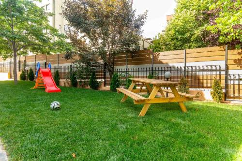 a yard with a picnic table and a playground at Heated Pool Villa in Thessaloniki - Urban Oasis in Thessaloniki