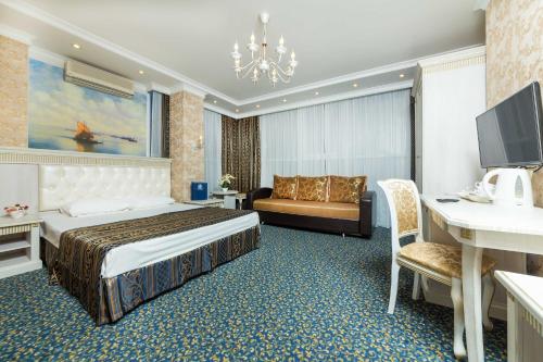 ein Hotelzimmer mit einem Bett und einem Schreibtisch in der Unterkunft Bogemania Hotel in Anapa
