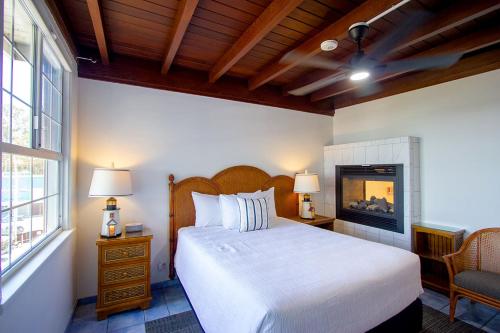 a bedroom with a white bed and a fireplace at Edgewater Beach Inn in Santa Cruz