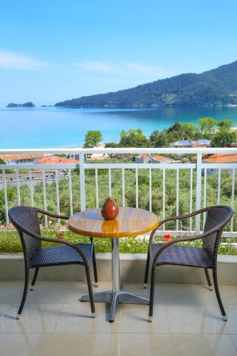 a table and chairs on a balcony with a view of the water at Hotel Emerald and Suites in Chrysi Ammoudia