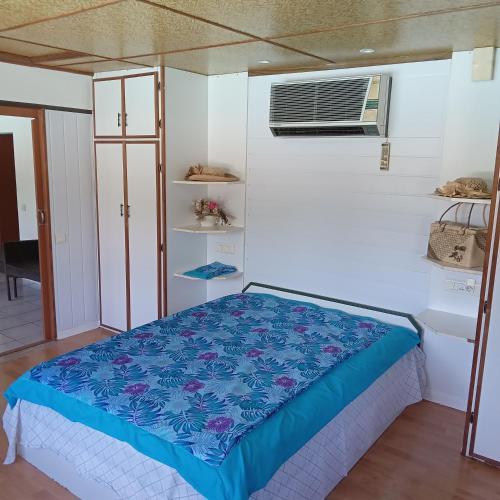 - une chambre avec un lit et la climatisation dans l'établissement Fare MIHIMANA, à Paea