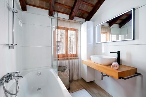 een badkamer met een bad, een wastafel en een spiegel bij Villa Carera old town of Rovinj-Rovigno in Rovinj