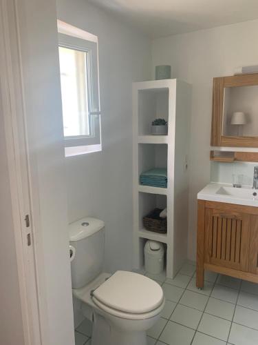 une salle de bain blanche avec des toilettes et un lavabo dans l'établissement Magnifique T1 entre mer et montagne, à Ascain