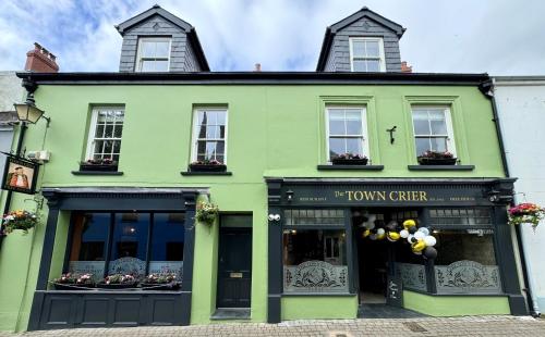 a green building with a tummy chef sign on it at The Town Crier, Tenby in Tenby
