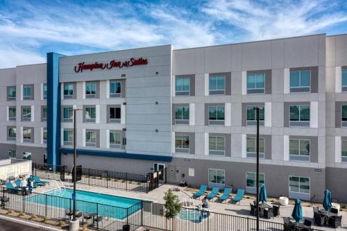 a hotel with a swimming pool in front of a building at Hampton Inn & Suites Bakersfield Central in Bakersfield