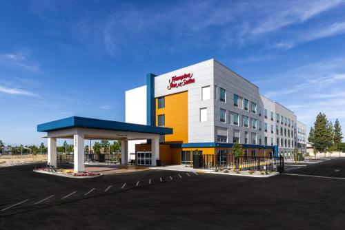 a building with a gas station in a parking lot at Hampton Inn & Suites Bakersfield Central in Bakersfield