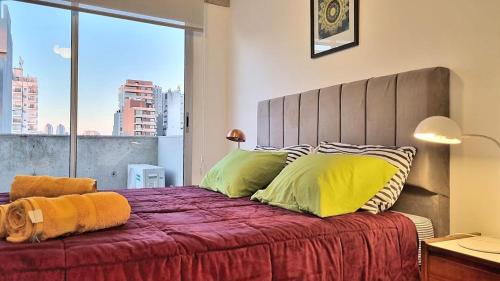 a bedroom with a large bed with a large window at Magico Palermo in Buenos Aires