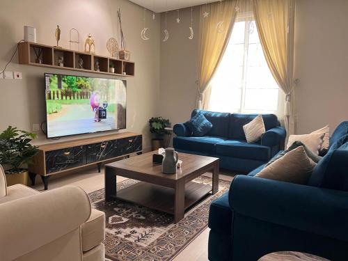 a living room with blue couches and a tv at شقة حي شوران in Al Madinah