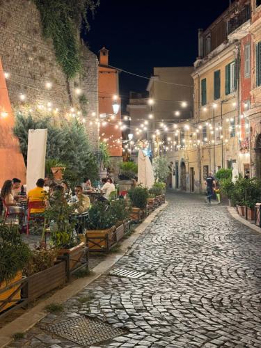 a cobblestone street at night with people sitting at tables at Il Vicoletto Marino in Marino