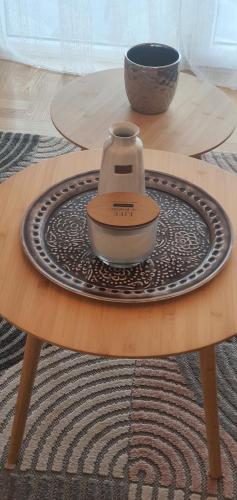 a tea kettle sitting on a plate on a table at Apartman TADEJ & FREE PARKING in Vrnjci