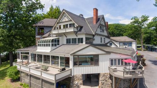 a large white house with windows and a roof at Depe Dene Lakeside Resort in Lake George