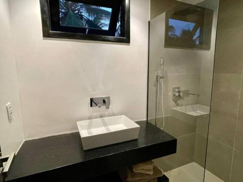 a bathroom with a sink and a glass shower at Vila Laguna Beach, kitesurf na Ilha do Guajiru in Itarema
