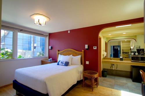 a bedroom with a large bed and a kitchen at Edgewater Beach Inn in Santa Cruz