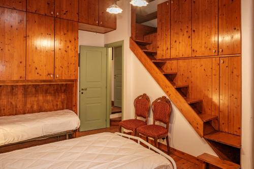 a bedroom with two beds and a staircase with wooden walls at La campagna e il mare in Catania