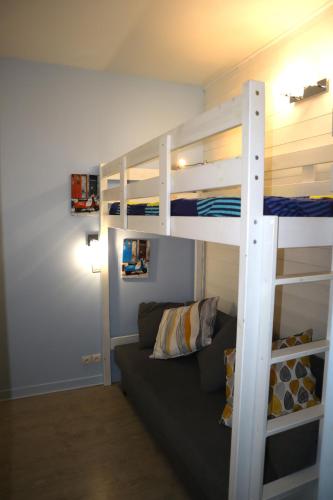 un salon avec un lit superposé et un canapé dans l'établissement 201, Les Ambassadeurs, à La Bourboule