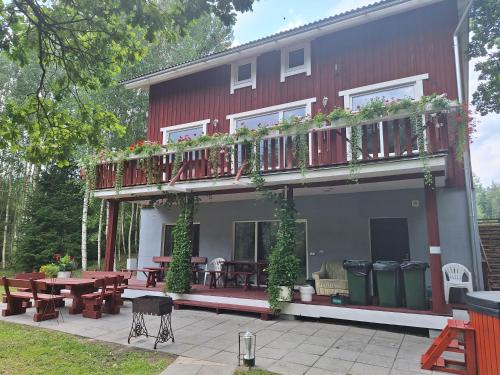 a building with a deck with tables and chairs at Toma pirts LIELĀ in Ikšķile