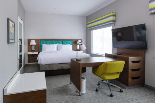 a hotel room with a bed and a desk with a computer at Hampton Inn & Suites Bakersfield Central in Bakersfield