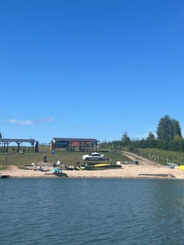 a beach with a group of boats on the water at Nad Sunowem Lake House in Chrzanowo