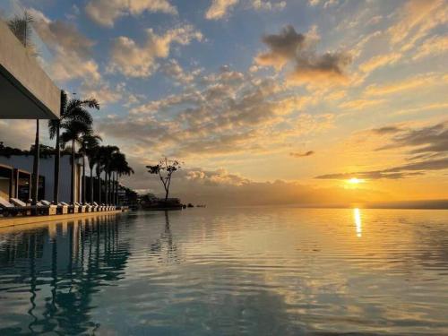 a swimming pool with a sunset in the background at New! Luxury 2bd 2ba Romantic Zone Largest Pool in PV Sea View Balcony in Puerto Vallarta