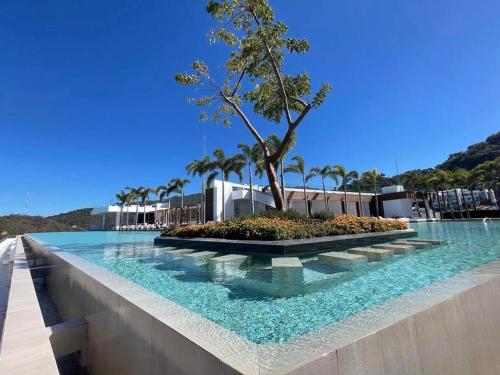 a swimming pool with a tree on top of it at New! Luxury 2bd 2ba Romantic Zone Largest Pool in PV Sea View Balcony in Puerto Vallarta