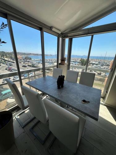 une table et des chaises dans une pièce avec une grande fenêtre dans l'établissement Résidence Port Helena Coudouliere - Magnifique appartement pour 4 personnes refait a neuf en duplex vue mer MAE-7151, à Six-Fours-les-Plages