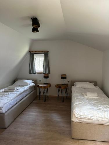 a bedroom with two beds and a window at Domki Sosnówka in Majdan Sopocki