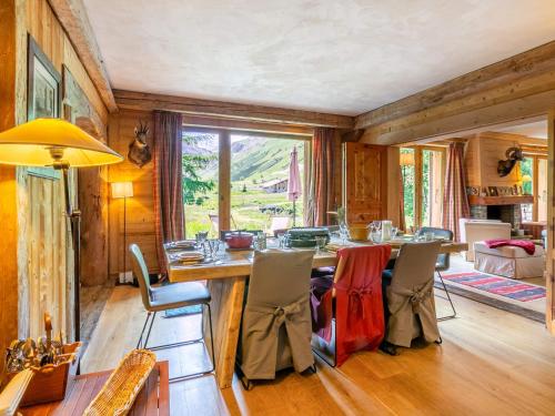 une salle à manger avec une grande table et des chaises en bois dans l'établissement Superbe appartement chalet, plein sud, au pied des pistes avec services haut de gamme - FR-1-694-356, à Val dʼIsère