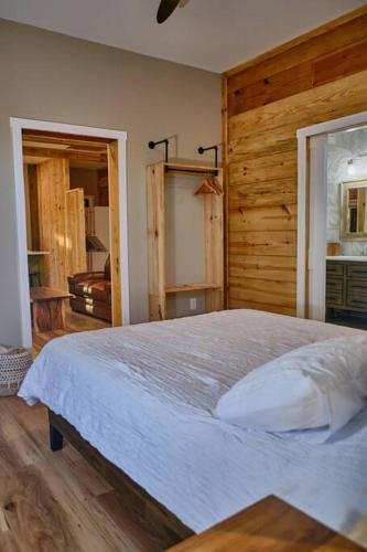 a bedroom with a large bed and a wooden wall at Serenity Barn in Mooresville