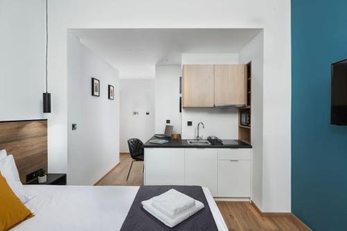 a room with a bed and a kitchen with a sink at The Meta Stay - Sunny Getaway with Rooftop Access in Athens