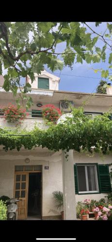 ein Haus mit Blumen an der Seite in der Unterkunft Giovani in Murter