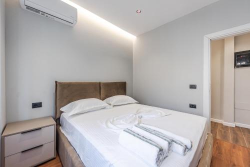 a bedroom with a bed with two towels on it at SR Apartments Golem in Golem