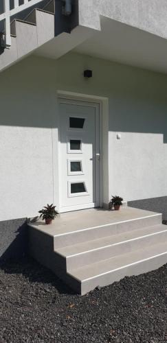 a door on a building with stairs and plants at Riverstone Retreat Villa in Jajce