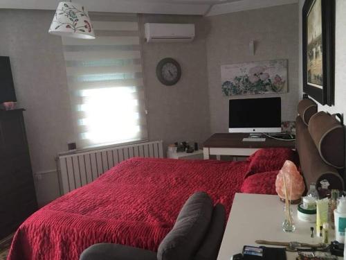 a bedroom with a red bed and a computer monitor at Private villa suitable for families with stunning sea views in Buyukcekmece