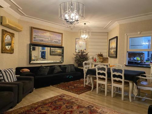 a living room with a couch and a table and chairs at Private villa suitable for families with stunning sea views in Buyukcekmece