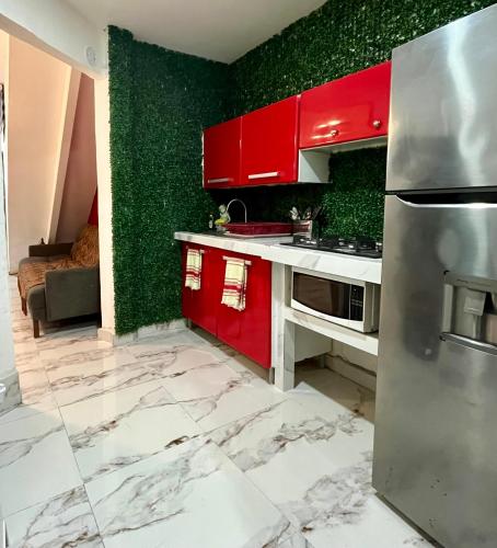 a kitchen with red cabinets and green walls at La Puerta Blanca #5 in Puerto Vallarta