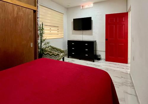 a bedroom with a red door and a tv at La Puerta Blanca #5 in Puerto Vallarta