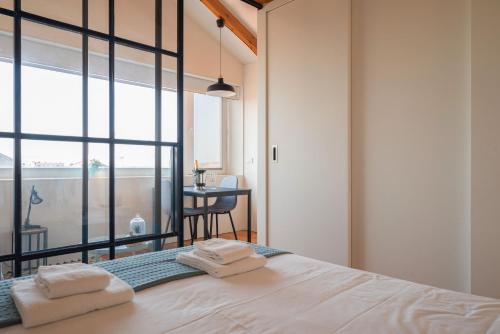 een slaapkamer met een bed met handdoeken erop bij Panoramic luxury apartment w AC Downtown and Metro in Porto