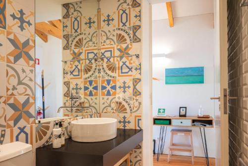 een badkamer met een wastafel en een tegelwand bij Panoramic luxury apartment w AC Downtown and Metro in Porto