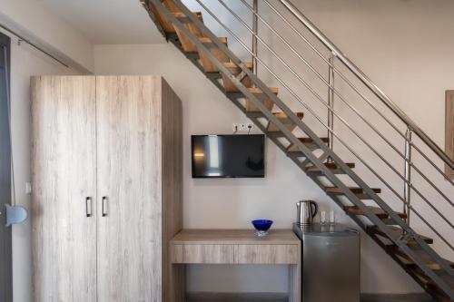 a living room with a tv and a staircase at Majestic house in Neos Marmaras