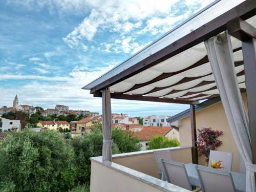 a balcony with chairs and a view of a city at Premium Apartments Tade Funtana in Funtana
