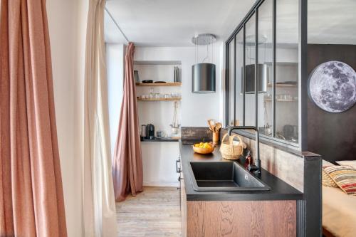 - une cuisine avec évier et un lit dans une chambre dans l'établissement Cœur de vie « La bulle », à Bagnères-de-Bigorre