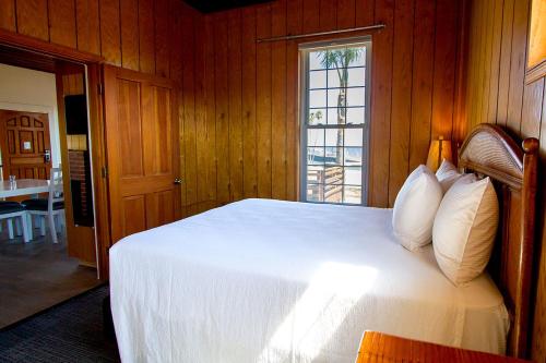 a bedroom with a white bed with a window at Edgewater Beach Inn in Santa Cruz