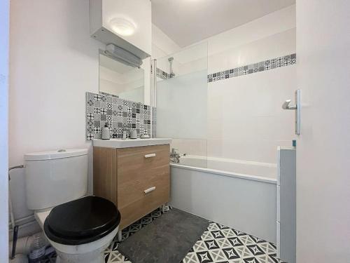 une salle de bain avec des toilettes noires, un lavabo et une baignoire dans l'établissement Grand appartement neuf entre Paris et Disneyland, à Noisy-le-Grand