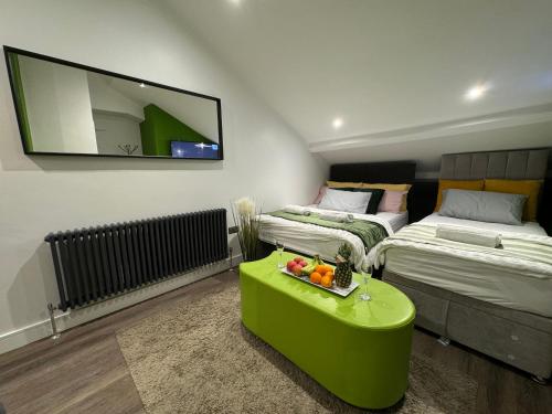 a room with two beds and a green coffee table at Southgate Luxury Apartments-Jaquzzi Bath-Private Parking- 2 Min M62 in Elland